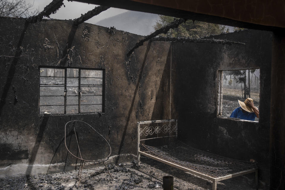 A resident looks at his home destroyed by wildfires in Maltrata, Mexico, Monday, March 25, 2024. Emergency crews are working to contain wildfires burning across parts of the high mountains in west-central Veracruz state. (AP Photo/Felix Marquez)