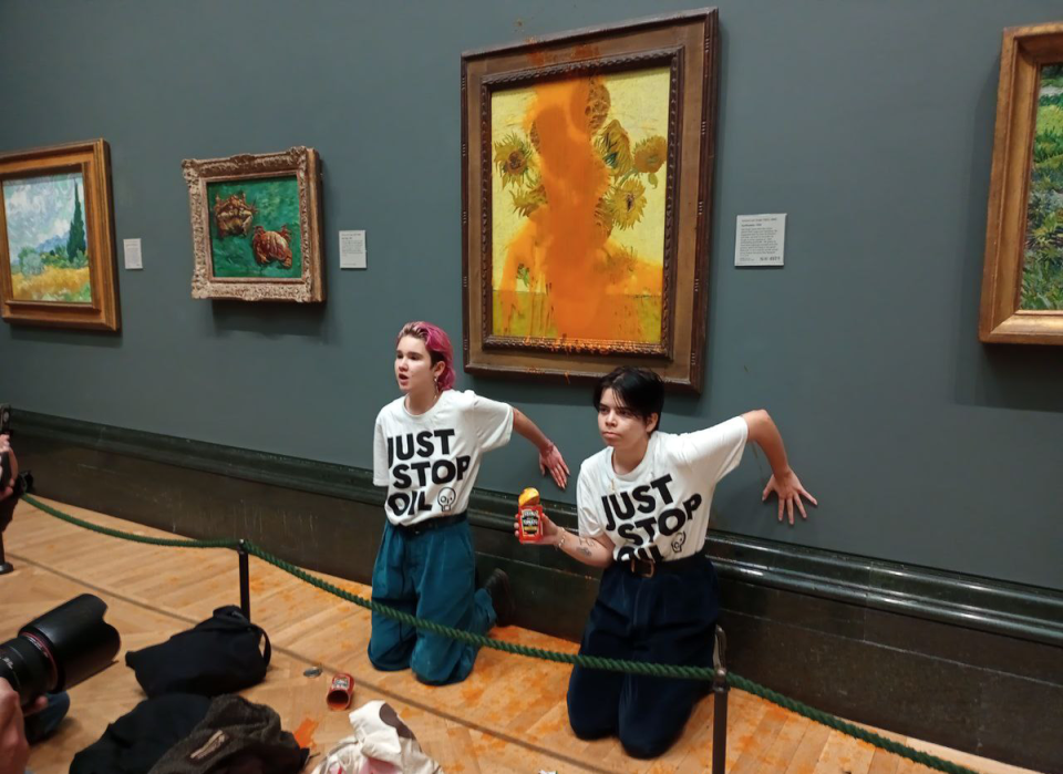 Just Stop Oil protesters glue their hands to the wall after throwing soup on Vincent Van Gogh’s Sunflowers painting at London’s National Gallery of Art (Just Stop Oil)