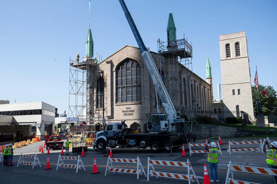 Workers install the last two spires on Mariners' Church in Detroit on Saturday, July 22, 2023.