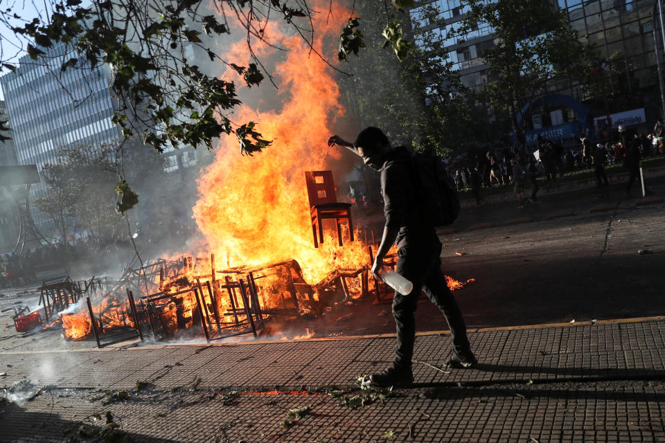 A demonstrator tosses a chair into an improvised bonfire during an anti-government protest in Santiago, Chile on Oct. 28, 2019. (Photo: Edgard Garrido/Reuters)