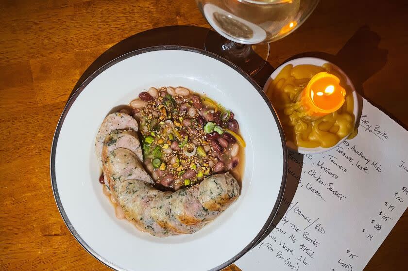 A bowl of chicken sausage with beans and wine at pop-up Baby Bistro from Miles Thompson and Andy Schwartz at Hotel Normandie