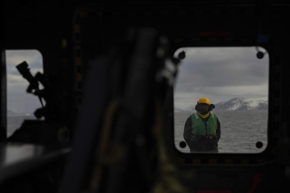 A mechanic stands on the deck after the landing of the helicopter on the French navy frigate Normandie during a patrol in a Norwegian fjord, north of the Arctic circle, Thursday March 7, 2024. The French frigate is part of a NATO force conducting exercises in the seas, north of Norway, codenamed Steadfast Defender, which are the largest conducted by the 31 nation military alliance since the cold war. (AP Photo/Thibault Camus)