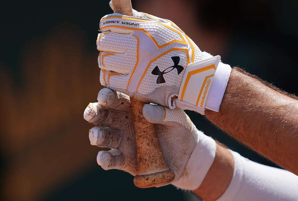 OAKLAND, CA - JULY 17:  Matt Olson #28 of the Oakland Athletics stand in the dugout wearing Under Armour batting gloves while holding onto his bat against the Seattle Mariners in the bottom of the fourth inning at Ring Central Coliseum on July 17, 2019 in Oakland, California.  (Photo by Thearon W. Henderson/Getty Images)