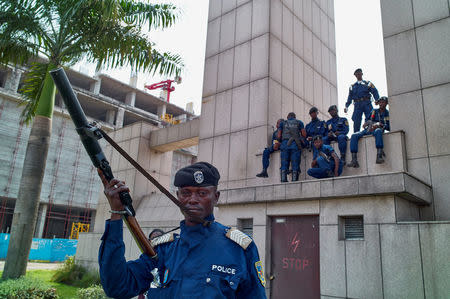 Congolese policemen sit on a monument at the Central Station, in Gombe, Kinshasa, Democratic Republic of Congo, December 19, 2016. REUTERS/Robert Carrubba