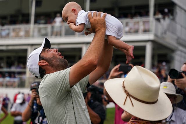 Scottie Scheffler hoists his son Bennett Ezra after winning the Tour Championship by four shots in Atlanta