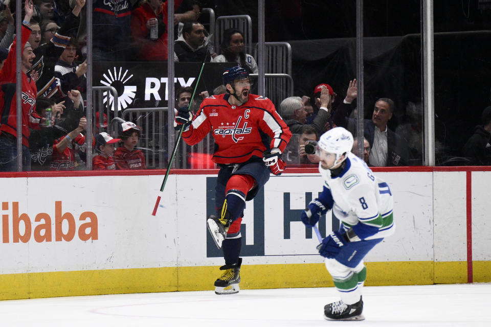 Washington Capitals left wing Alex Ovechkin, left, celebrates after his goal during the second period of an NHL hockey game against the Vancouver Canucks, Sunday, Feb. 11, 2024, in Washington. Canucks right wing Conor Garland, right, looks on. (AP Photo/Nick Wass)