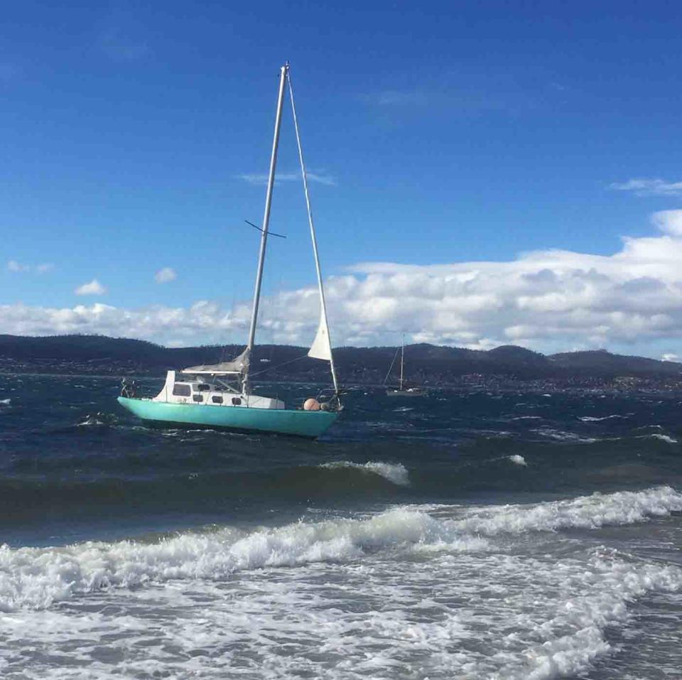 Wild winds forced this boat to break from its moorings at Hobart's Nutgrove Beach, Tasmania.