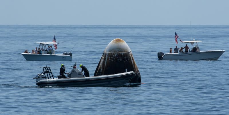 Support teams and curious recreational boaters arrive at the SpaceX Crew Dragon Endeavour spacecraft shortly after it landed with NASA astronauts Robert Behnken and Douglas Hurley onboard in the Gulf of Mexico