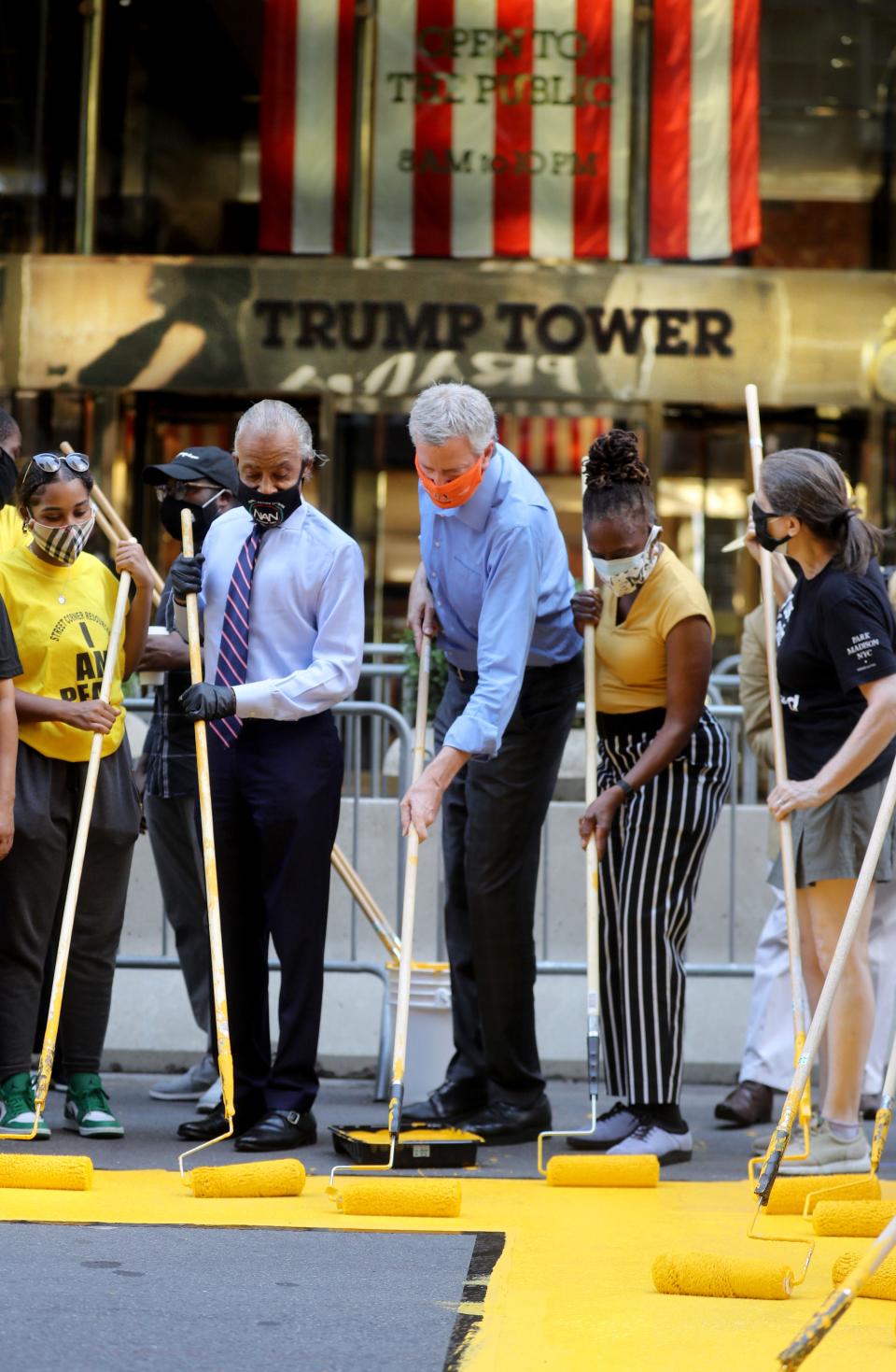 New York City Mayor Bill de Blasio, his wife Chirlane McCray, and the Rev. Al Sharpton assist activists in painting Black Lives Matter on Fifth Ave. in front of Trump Tower