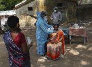 A health worker takes a nasal swab sample of a woman to test for COVID-19 in Hyderabad, India, Friday, May 7, 2021. With coronavirus cases surging to record levels, Indian Prime Minister Narendra Modi is facing growing pressure to impose a harsh nationwide lockdown amid a debate whether restrictions imposed by individual states are enough. (AP Photo /Mahesh Kumar A.)