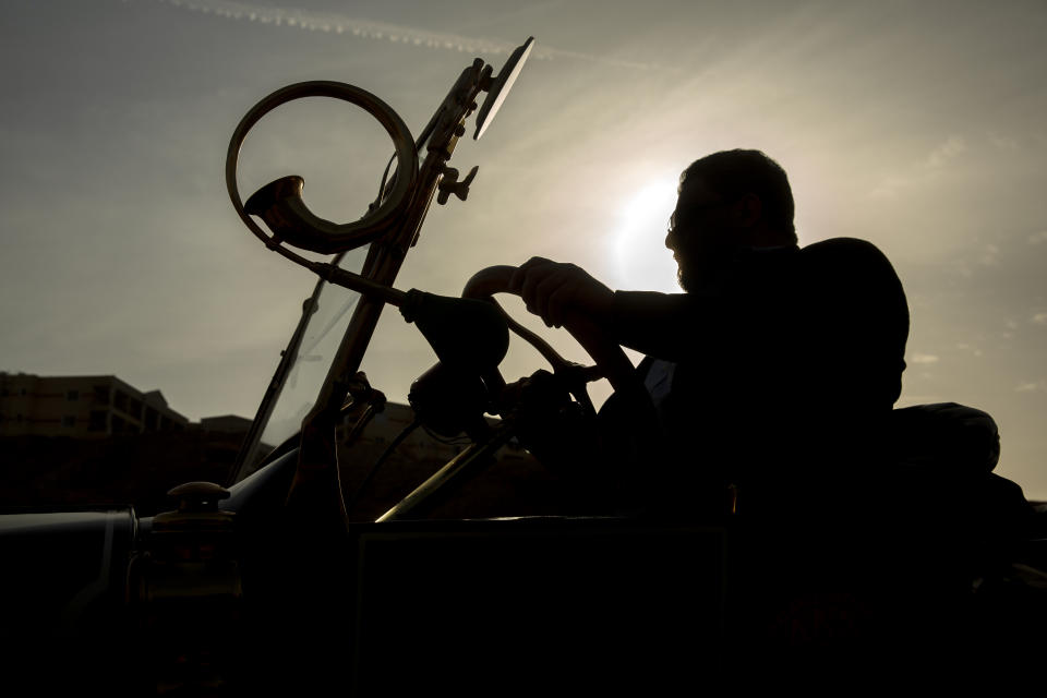 Egyptian collector Mohamed Wahdan sits in how 1924 Ford T at a public show in Cairo, Egypt, Saturday, March 19, 2022. The car once belonged to Egypt's King Farouk's and is a part of over 250 vintage, antique and classic cars Wahdan collected over the past 20 years. (AP Photo/Amr Nabil)