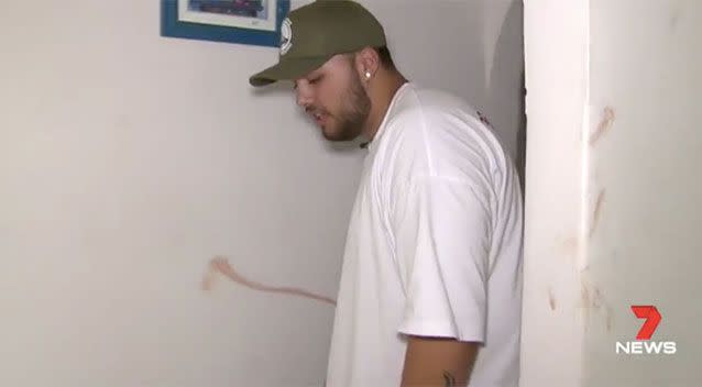 Logan shows the blood smear on the wall where he and his friends dragged the intruder. Source: 7 News