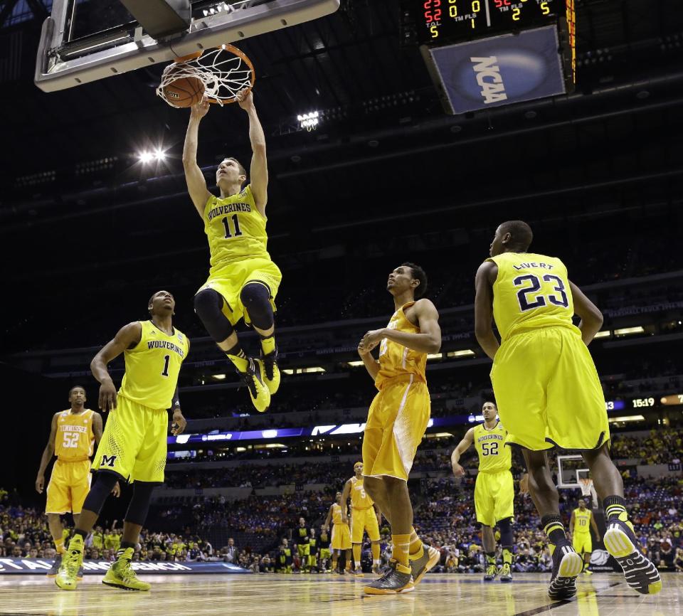 Michigan's Nik Stauskas (11) dunks during the first half of an NCAA Midwest Regional semifinal college basketball tournament game against the Tennessee Friday, March 28, 2014, in Indianapolis. (AP Photo/David J. Phillip)