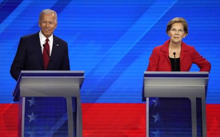 Former Vice President Joe Biden and Senator Elizabeth Warren stand behind their podiums at the start of at the 2020 Democratic U.S. presidential debate in Houston