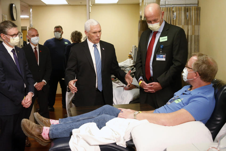 Vice President Mike Pence, center, visits a patient who survived the coronavirus and was going to give blood during a tour of the Mayo Clinic on April 28, 2020, in Rochester, Minn. as he toured the facilities supporting COVID-19 research and treatment. (Jim Mone/AP)