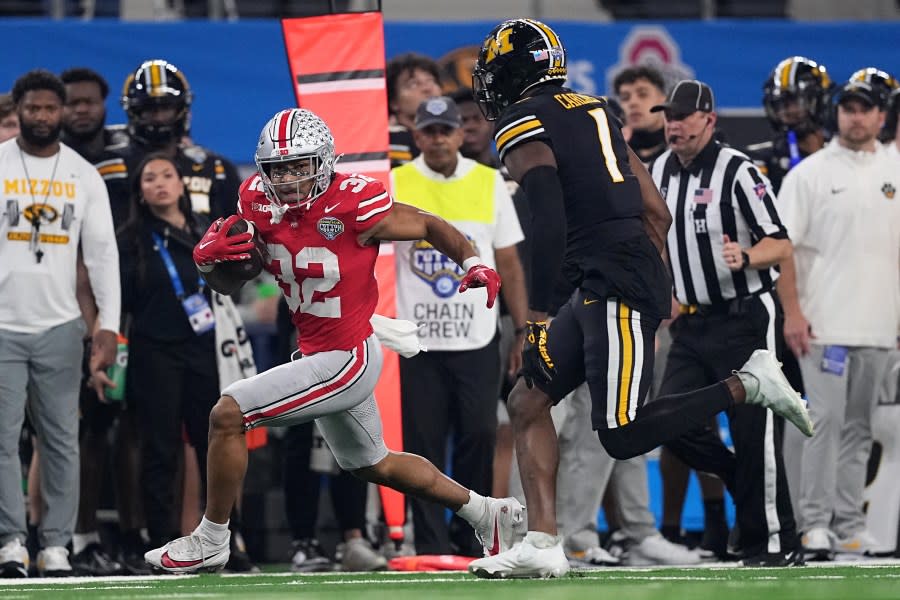 ARLINGTON, TEXAS – DECEMBER 29: TreVeyon Henderson #32 of the Ohio State Buckeyes runs the ball against Jaylon Carlies #1 of the Missouri Tigers during the first quarter in the Goodyear Cotton Bowl at AT&T Stadium on December 29, 2023 in Arlington, Texas. (Photo by Sam Hodde/Getty Images)
