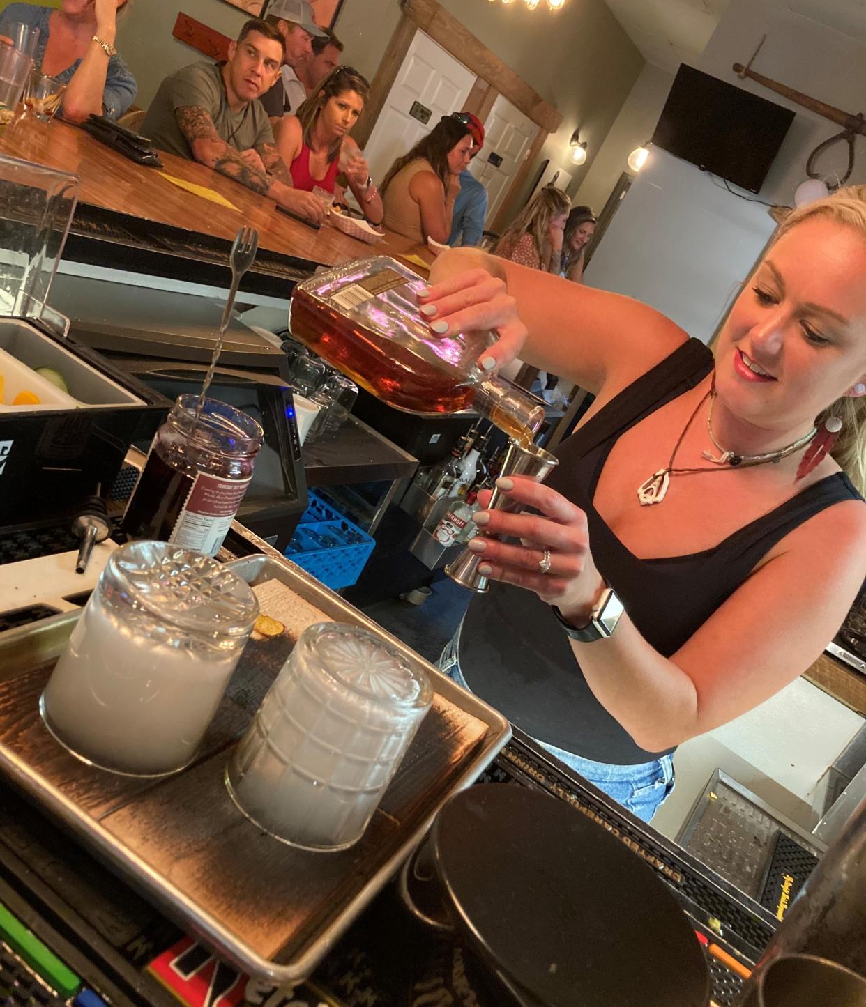 A bartender makes Cedar Smoke Old Fashioned cocktails at the Cast Iron Kitchen Kanteen at 8024 Market St., Porters Neck.