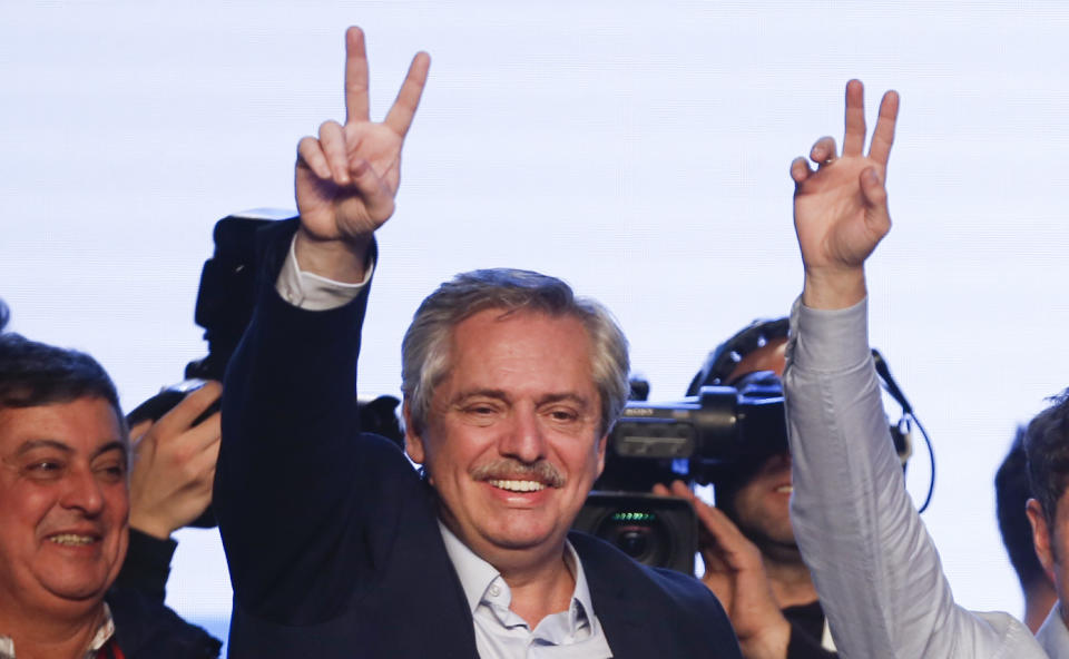 Presidential candidate Alberto Fernandez flashes a victory sign to supporters at the "Frente de Todos" party headquarters after primary elections in Buenos Aires, Argentina, Sunday, Aug. 11, 2019. The "Frente de Todos" presidential ticket with former President Cristina Fernández emerged as the strongest vote-getter in Argentina’s primary elections Sunday, indicating conservative President Mauricio Macri will face an uphill battle going into general elections in October. (AP Photo/Sebastian Pani)