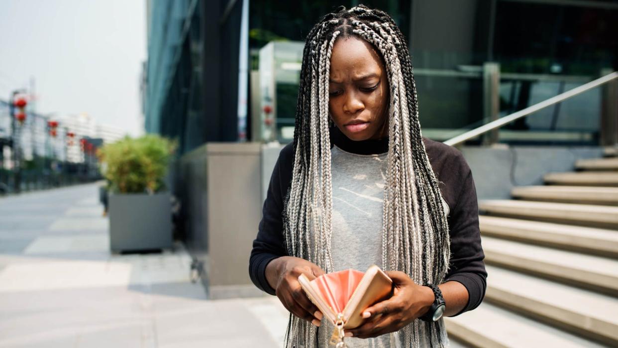 Woman checking her wallet with a concerned expression