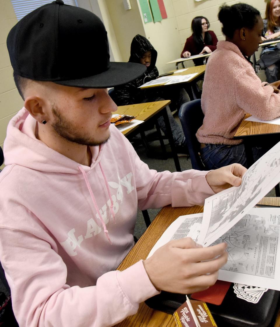 Orchard Center High School student Rodney Mayes, 17, looks at the maps of Ukraine while former 2004 OCHS graduate Ricky Cain talks about living abroad.