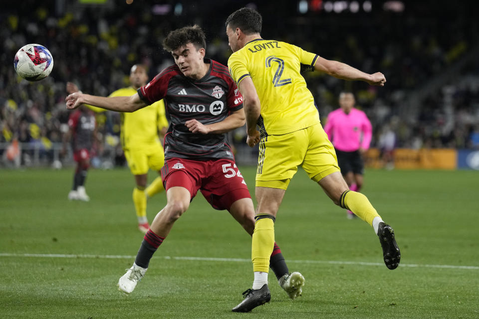 Nashville SC defender Daniel Lovitz (2) heads the ball past Toronto FC midfielder Alonso Coello (52) during the second half of an MLS soccer match Saturday, April 8, 2023, in Nashville, Tenn. (AP Photo/Mark Humphrey)