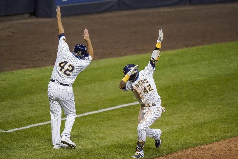 Milwaukee Brewers' Orlando Arcia celebrates with third base coach Ed Sedar after hitting a home run during the seventh inning of a baseball game against the Pittsburgh Pirates Saturday, Aug. 29, 2020, in Milwaukee. (AP Photo/Morry Gash)