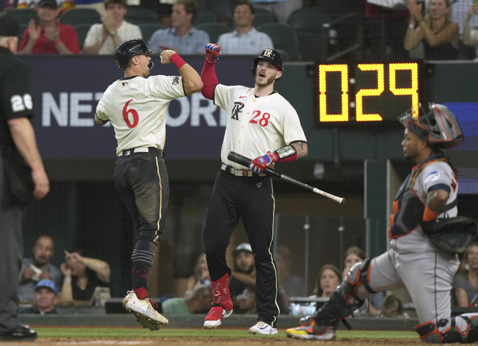 Texas Rangers' Josh Jung (6) celebrates after his solo home run with Jonah Heim (28) as Houston Astros catcher Martin Maldonado, right, looks on during the fourth inning of a baseball game in Arlington, Texas, Friday, June 30, 2023. (AP Photo/LM Otero)