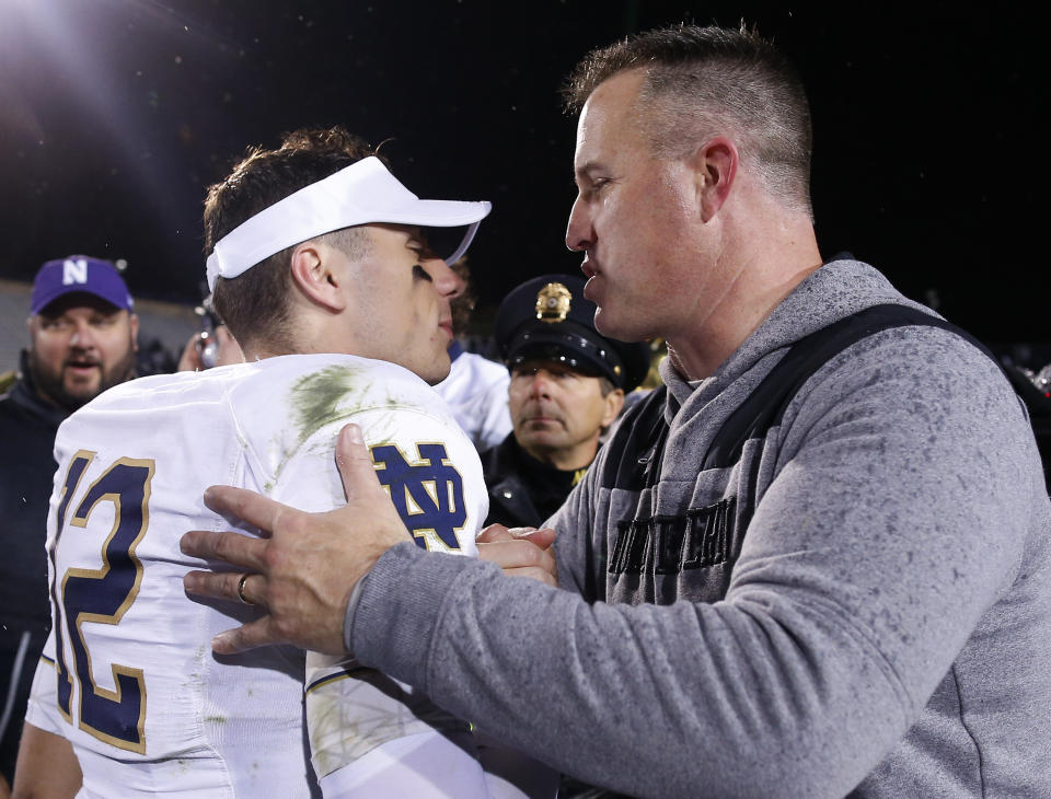 Notre Dame's Ian Book, left, is congratulated by Northwestern's coach Pat Fitzgerald after their NCAA college football game Saturday, Nov. 3, 2018, in Evanston, Ill. (AP Photo/Jim Young)