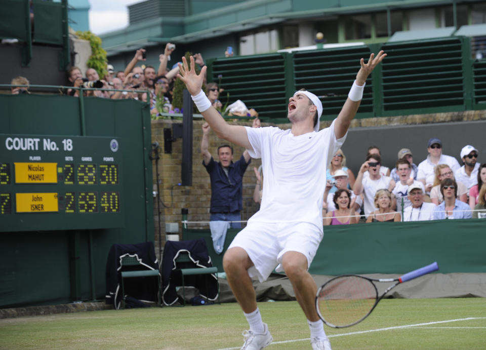 Isner, épuisé, s'effondre au sol après le point gagnant.  (David Ashdown/Getty Images)