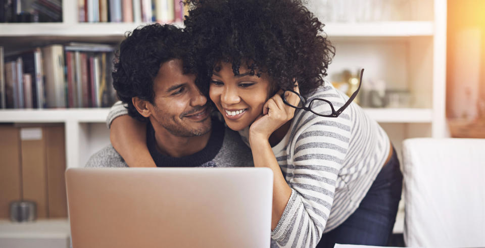 couple snuggling looking at laptop