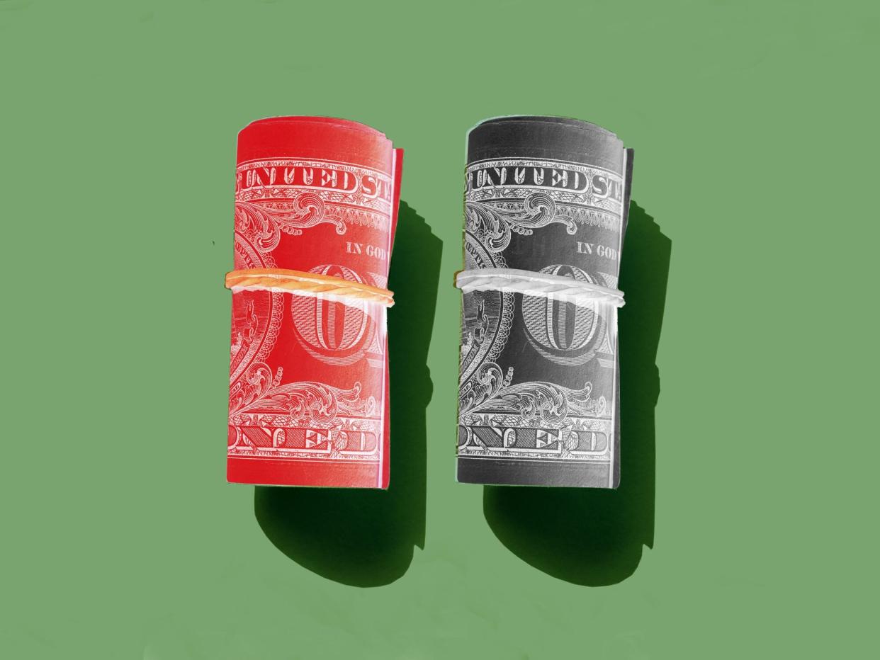 two rolls of dollar bills. one inverted red, the other inverted black.