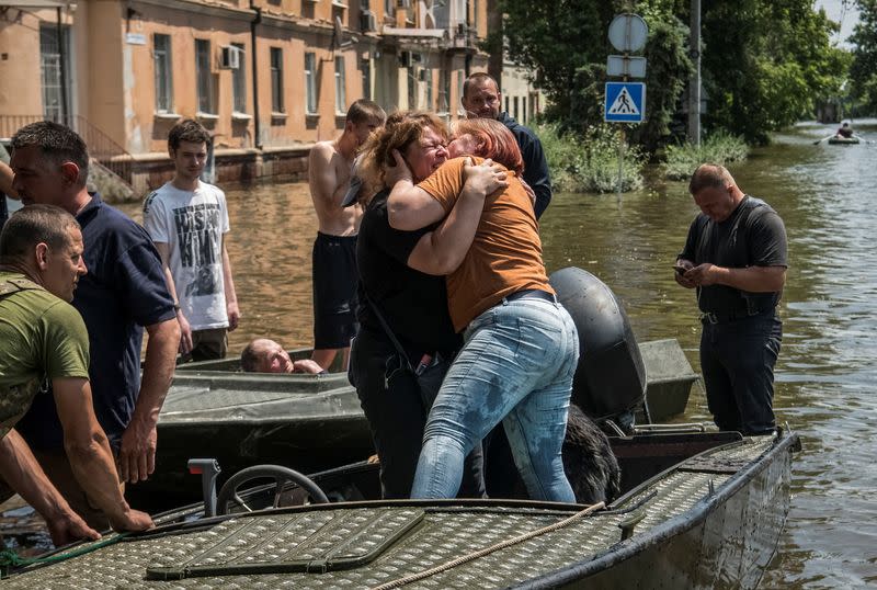 Local residents react after evacuation from a flooded area after the Nova Kakhovka dam breached, in Kherson