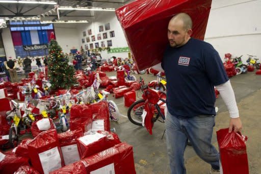 A USO volunteer carries donated gifts military families at Fort Belvoir. The USO's metropolitan Washington branch is behind Project USO Elf, which has grown fast in response to the recession that hit the US hard in 2008 and never really left