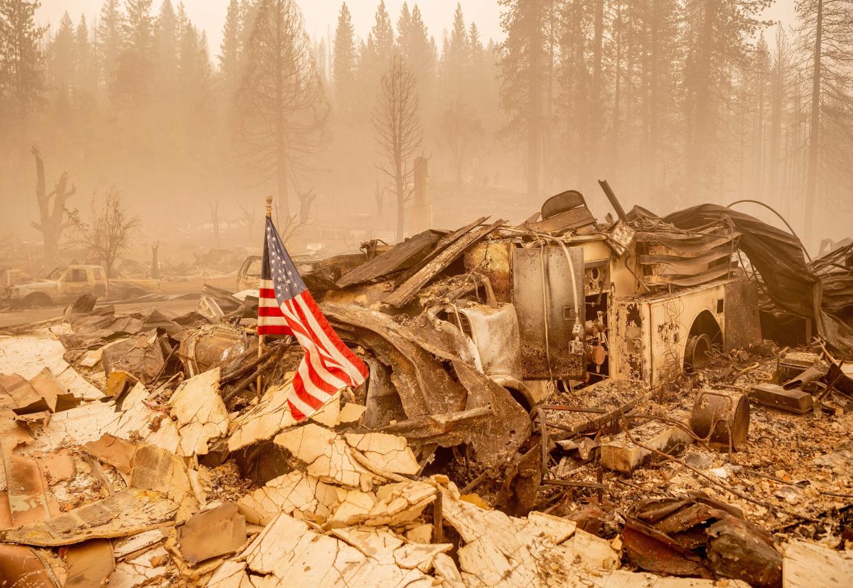 An American flag is placed on a burned fire engine at a burned fire station in downtown Greenville, California on Aug. 7, 2021. The Dixie Fire has now ravaged 446,723 acres in four counties, up from the previous day's 434,813.