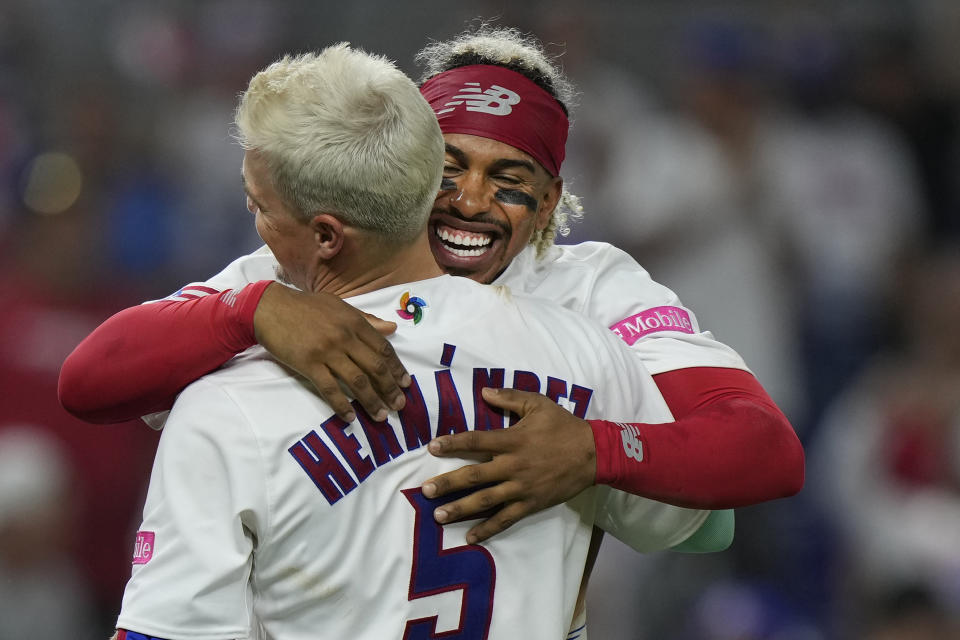 Puerto Rico's Francisco Lindor, rear, hugs Enrique Hernandez (5) after Hernandez hit a single to score Martin Maldonado for the win during the eighth inning of a World Baseball Classic game against Israel, Monday, March 13, 2023, in Miami. Puerto Rico beat Israel 10-0 with the 8th inning run-rule walk off and a combined perfect game. (AP Photo/Wilfredo Lee)