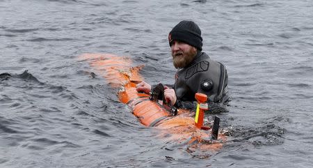 Subsea engineer John Haig launches Munin, an intelligent marine robot, to explore Loch Ness in Scotland, Britain April 13, 2016. REUTERS/Russell Cheyne