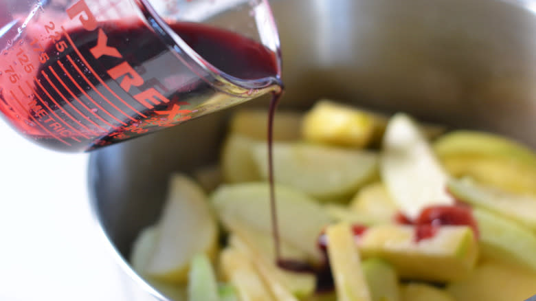 pouring pomegranate juice on apples