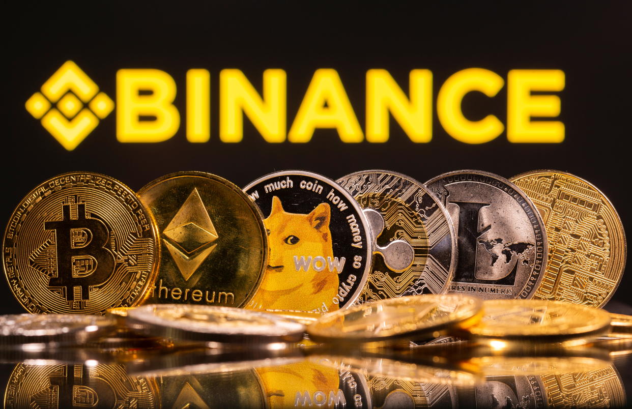 Representations of cryptocurrencies Bitcoin, Ethereum, DogeCoin, Ripple, and Litecoin are seen in front of a displayed Binance logo in this illustration taken, June 28, 2021. REUTERS/Dado Ruvic/Illustration