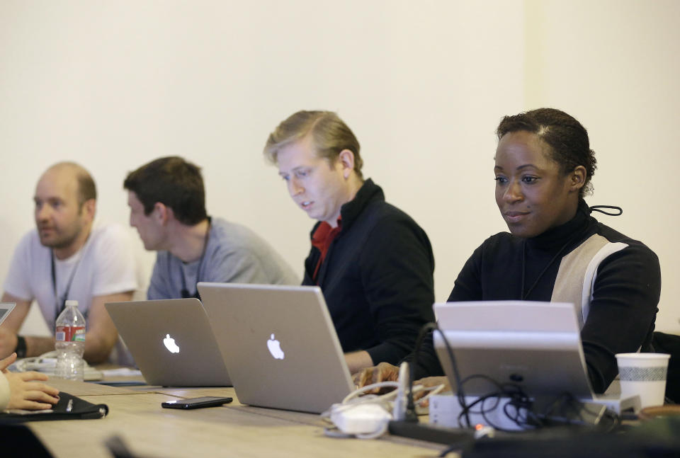 In this Saturday, Feb. 8, 2014 photo, Fanya Young, right, and other participants work on their computers during a coding and team formation session at FinCapDev San Francisco Hackathon in San Francisco. A record 1,500 hackathons around the world are planned for this year, up from just a few dozen in 2010, and their focus is broadening from developing lucrative apps to solving problems with coding for an array of issues including dental, fashion, immigration, transgender and social justice. (AP Photo/Jeff Chiu)