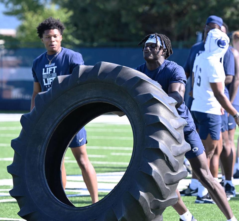 Penn State’s Malick Meiga, right, flips a tire during the Nittany Lions annual Lift For Life event at University Park Thursday, June 30, 2022.