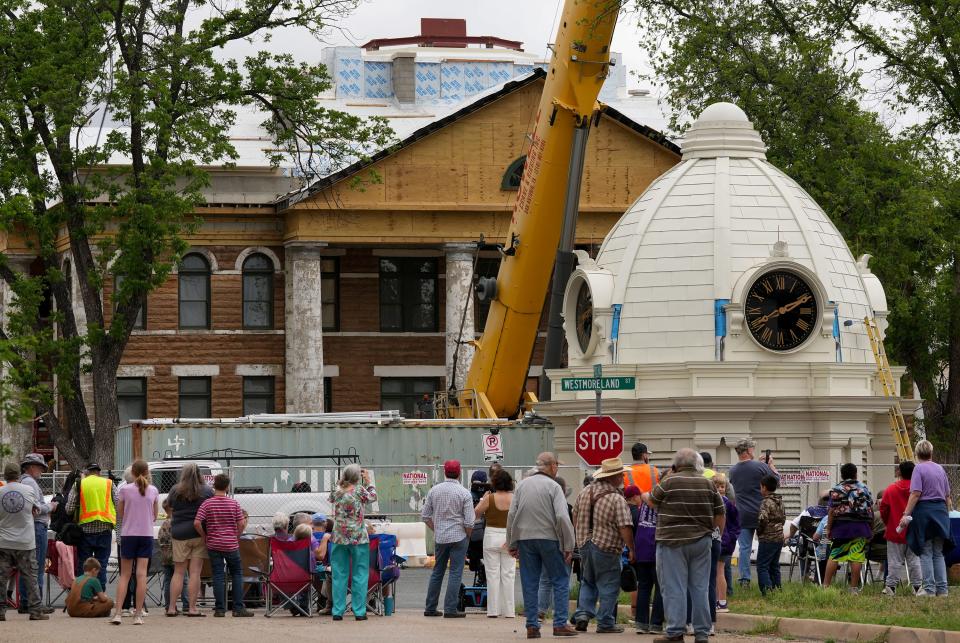 Residents gather on April 19 to watch workers set a new crown on top of the Mason County Courthouse. People started staking out their viewing spots around 7 a.m., and a fourth grade class studying Texas history was allowed to watch, too.
