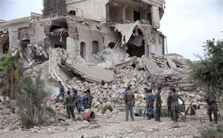 Forces loyal to Syria's President Bashar al-Assad stand on debris at a hotel used by Assad's forces, in old Aleppo May 8, 2014. REUTERS/George Ourfalian