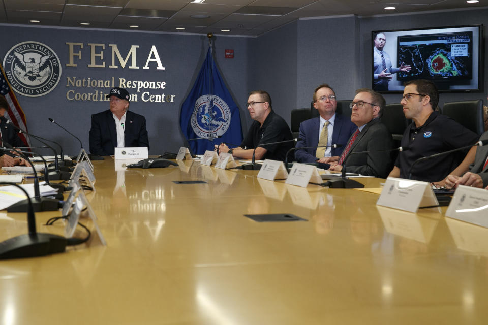 President Donald Trump, left, listens as Kenneth Graham, director of NOAA's National Hurricane Center, on screen, gives an update during a briefing about Hurricane Dorian at the Federal Emergency Management Agency (FEMA), Sunday, Sept. 1, 2019, in Washington, at right of Trump is Acting Administrator Pete Gaynor, Federal Emergency Management Agency, and acting White House chief of staff, Mick Mulvaney, Environmental Protection Agency (EPA) Administrator Andrew Wheeler, and Neil Jacobs, Assistant Secretary of Commerce for Environmental Observation and Prediction. (AP Photo/Jacquelyn Martin)