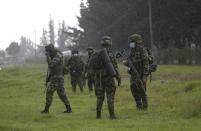 Colombian soldiers stand guard near a highway while anti-government protesters clash with police, in Gachancipa, Colombia, Friday, May 7, 2021. The protests that began last week over a tax reform proposal continue despite President Ivan Duque's withdrawal of the tax plan on Sunday, May 2. (AP Photo/Ivan Valencia)