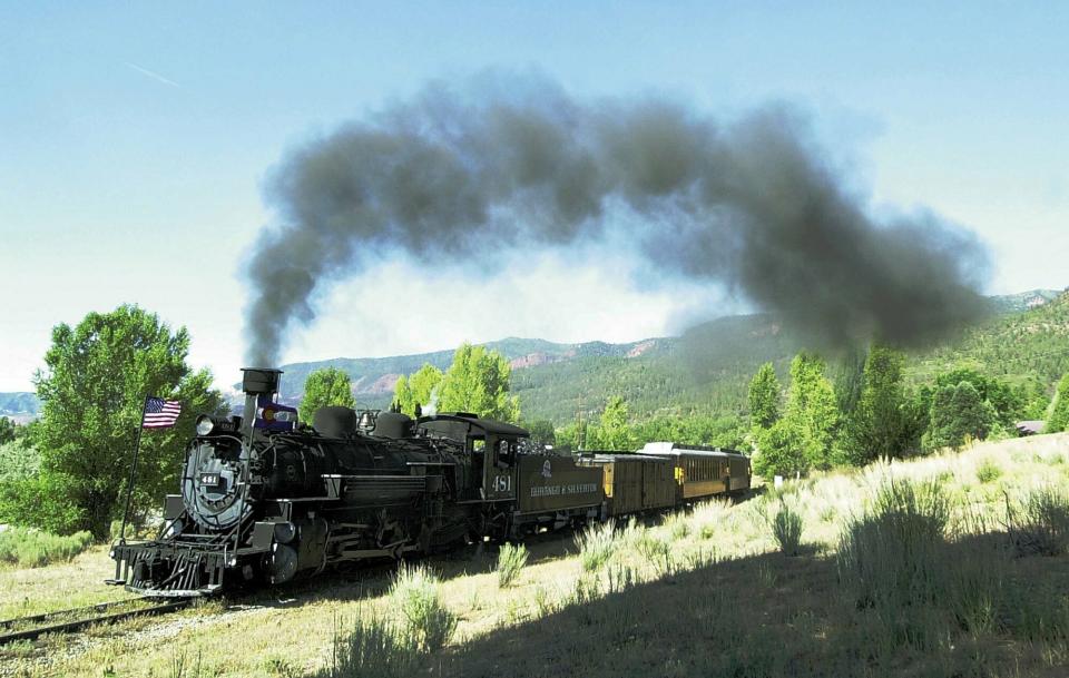 FILE - In this July 13, 2002 file photo, a Durango & Silverton Narrow Gauge Railroad train begins the climb out of the Animas Valley north of Durango, Colo. The U.S. Attorney’s Office alleges that a coal-burning engine from the railroad threw cinders or other material onto brush near its track last year, sparking a wildfire that burned about 85 square miles. The railroad carries passengers between Durango and Silverton, passing through the San Juan National Forest. (Dustin Bradford/The Durango Herald via AP, File)