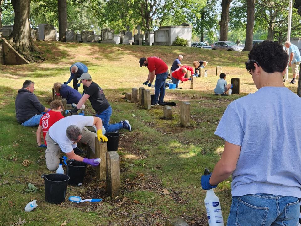 Friends, family, and Scouts working to clean the headstones on restoration day in North Arlington Sept. 16. 2023.