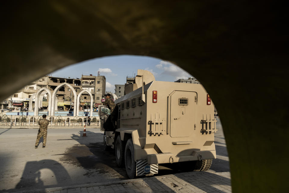 U.S.-backed Syrian Democratic Forces (SDF) fighters stand guard at Al Naeem Square, in Raqqa, Syria, Monday, Feb. 7, 2022. Raqqa, the former de facto capital of the self-proclaimed IS caliphate and home to about 300,000, is now free, but many of its residents try to leave. Those with capital are selling their property to save up for the journey to Turkey. Those without money struggle to get by. (AP Photo/Baderkhan Ahmad)