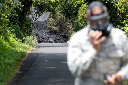 Lieutenant Colonel Charles Anthony, of the Hawaii National Guard, measures sulfur dioxide gas levels at a lava flow on Highway 137 southeast of Pahoa during ongoing eruptions of the Kilauea Volcano in Hawaii, U.S., May 20, 2018. REUTERS/Terray Sylvester