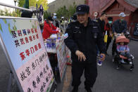 A security guard receives a sticker declaring he is vaccinated against the coronavirus at a stand promoting free shots outside an entrance to the Forbidden City in Beijing on Wednesday, April 14, 2021. China's success at controlling COVID-19 has resulted in a population that has seemed almost reluctant to get vaccinated. It is now accelerating its inoculation campaign by offering incentives — free eggs, store coupons and discounts on groceries and merchandise — to those getting a shot. (AP Photo/Ng Han Guan)