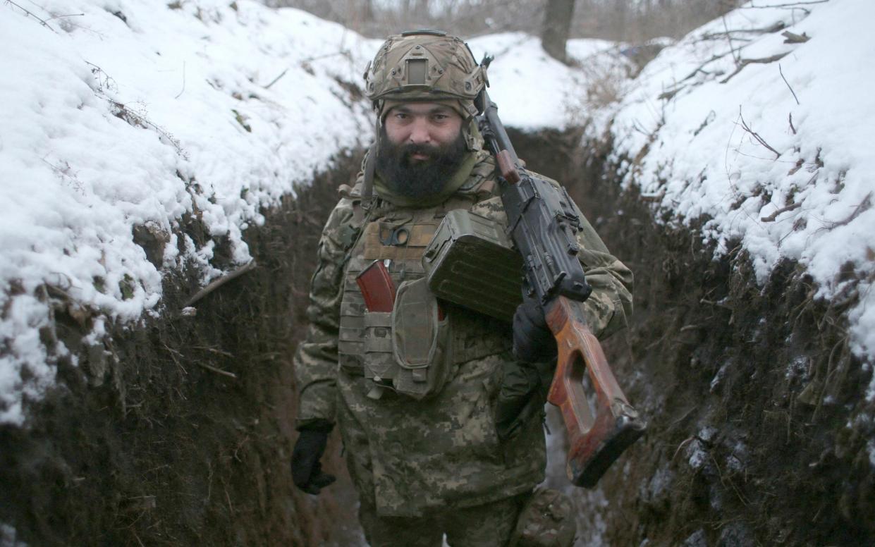 Ukrainian Military Forces serviceman poses with his weapons in a trench on the frontline with the Russia-backed separatists near Zolote village, in the eastern Lugansk region, on January 21, 2022. - Ukraine's Foreign Minister Dmytro Kuleba on January 22, 2022, - ANATOLII STEPANOV/AFP via Getty Images